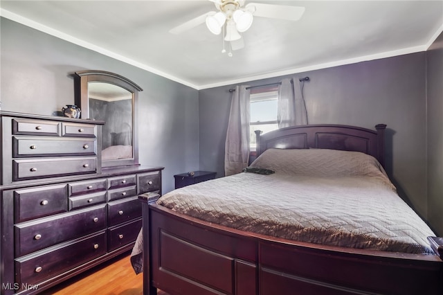 bedroom featuring ceiling fan, ornamental molding, and light hardwood / wood-style flooring