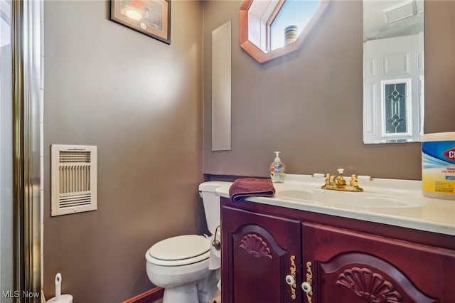 bathroom featuring vanity, heating unit, and toilet