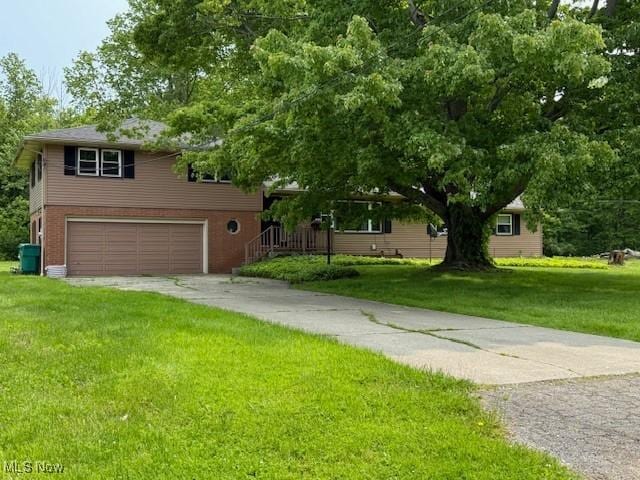 2500 Douglas Rd, Ashtabula, OH 44004 - view of front of home with a garage, driveway, a front yard, and brick siding