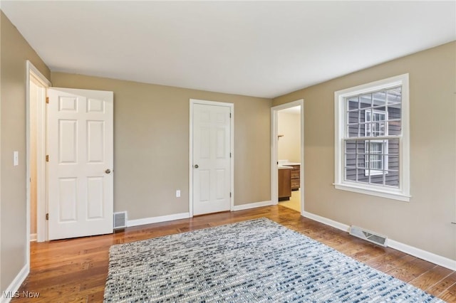 bedroom featuring visible vents, baseboards, and wood finished floors