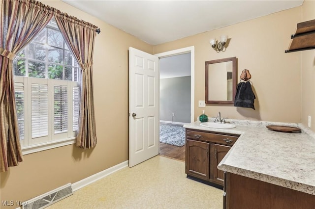 bathroom featuring visible vents, vanity, and baseboards