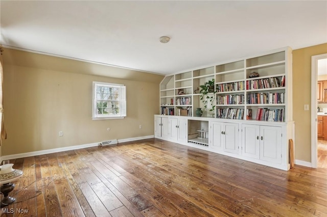 interior space with visible vents, baseboards, and hardwood / wood-style floors