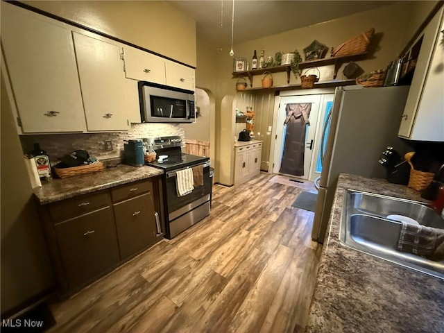 kitchen featuring sink, white cabinets, light wood-type flooring, and appliances with stainless steel finishes