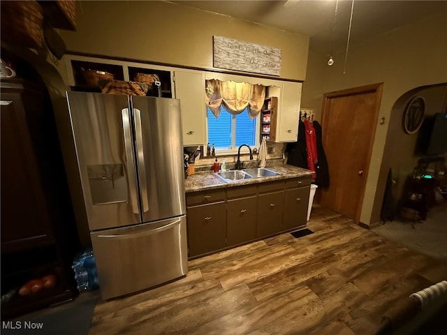 kitchen featuring sink, light hardwood / wood-style floors, and stainless steel refrigerator with ice dispenser