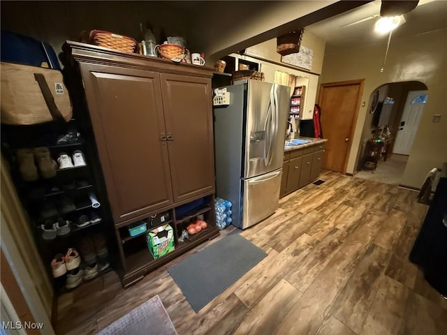 kitchen featuring ceiling fan, light hardwood / wood-style floors, and stainless steel refrigerator with ice dispenser