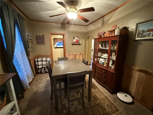 dining space featuring carpet flooring, ceiling fan, and crown molding