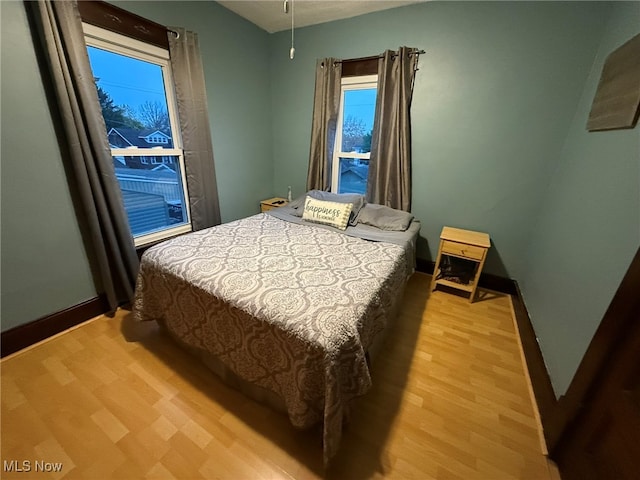 bedroom with light hardwood / wood-style floors and multiple windows