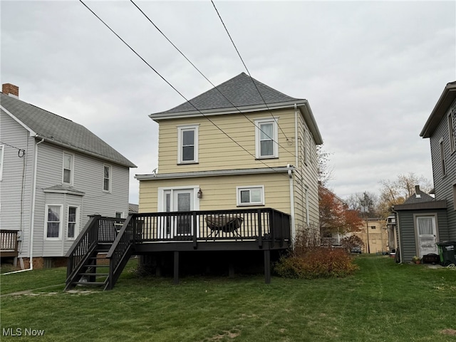 rear view of house featuring a yard and a deck