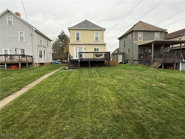 back of property with a lawn and a wooden deck