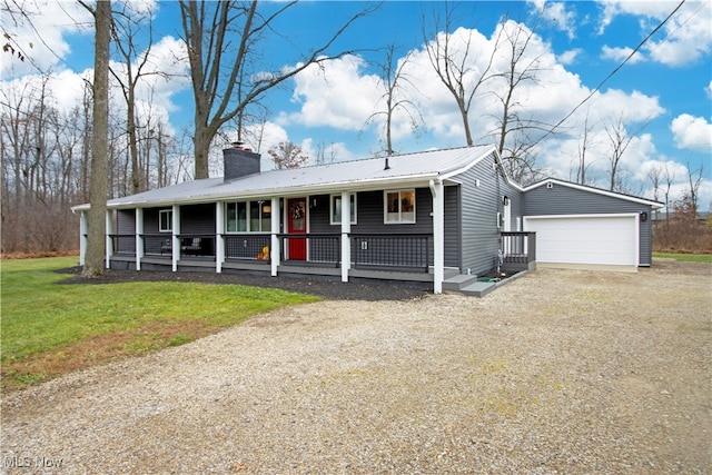 view of front of property with covered porch, a garage, and a front yard