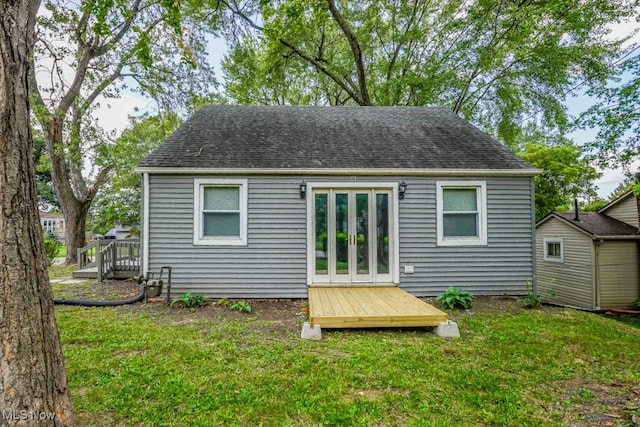 rear view of house with french doors, a yard, and a deck