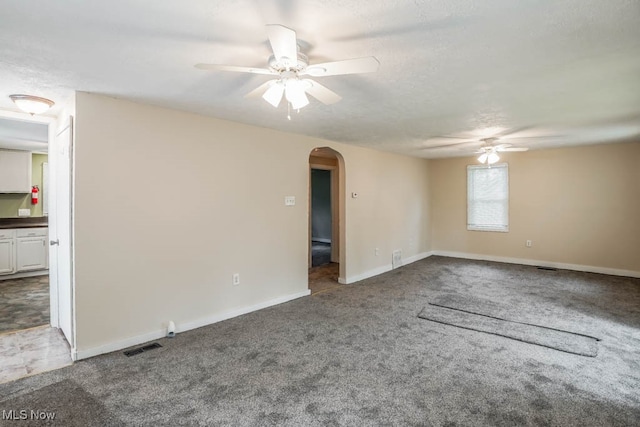 carpeted spare room with ceiling fan and a textured ceiling