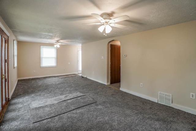 unfurnished room featuring ceiling fan, a textured ceiling, and dark colored carpet