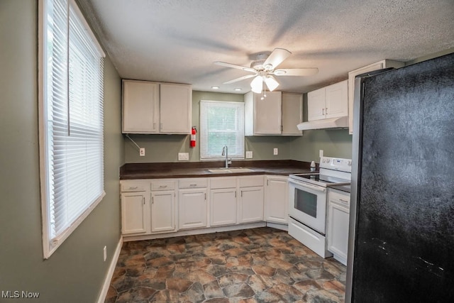 kitchen with ceiling fan, sink, white electric stove, stainless steel fridge, and white cabinets