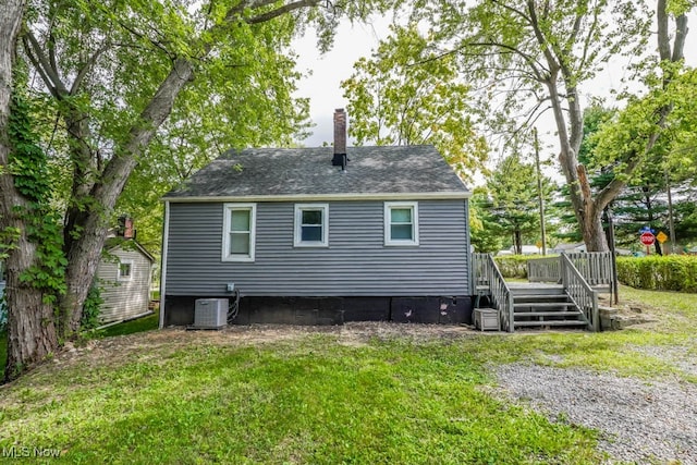 back of property featuring a yard, a wooden deck, and central AC