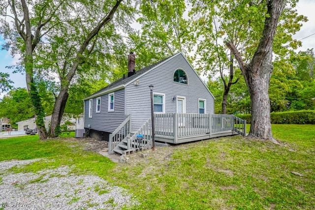 rear view of house with a lawn and a wooden deck