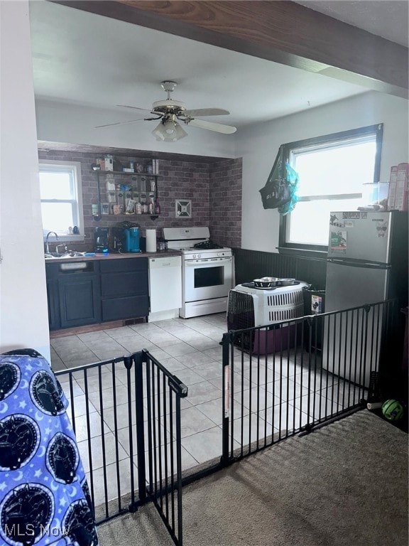 kitchen with ceiling fan, white range, light carpet, and stainless steel refrigerator