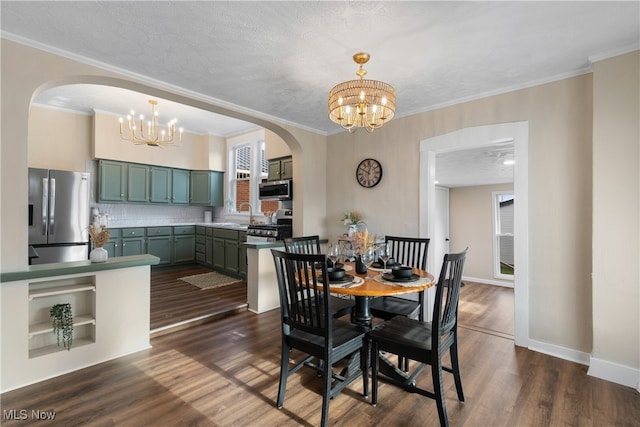 dining area with a textured ceiling, dark hardwood / wood-style floors, an inviting chandelier, and crown molding