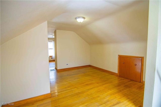 bonus room with lofted ceiling and hardwood / wood-style floors