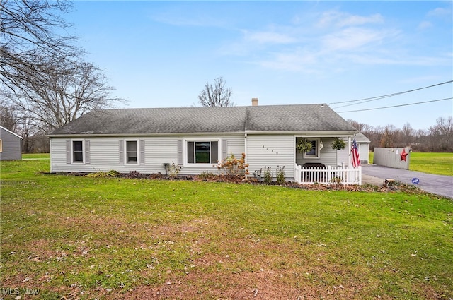 view of front of home featuring a front yard, a porch, and a garage