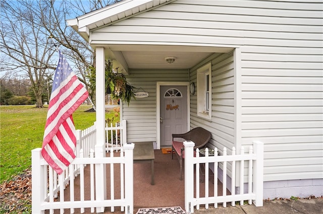 doorway to property featuring a lawn and a porch