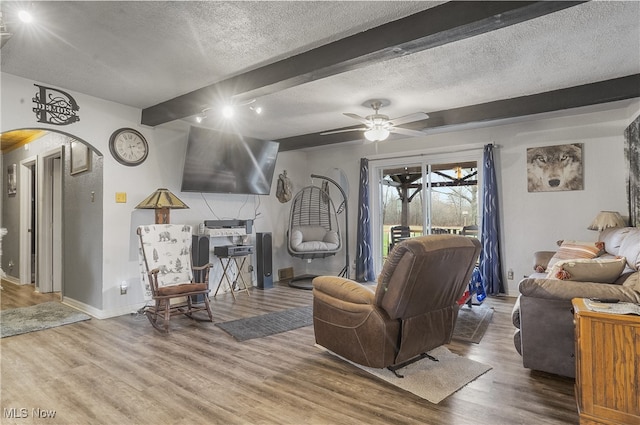 living room with beam ceiling, wood-type flooring, and a textured ceiling