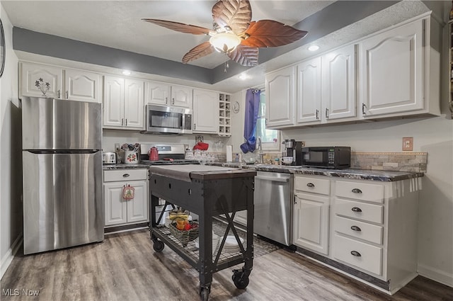 kitchen featuring stainless steel appliances, white cabinetry, and ceiling fan