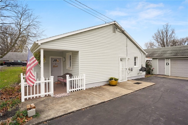 view of home's exterior with covered porch, an outdoor structure, and a garage