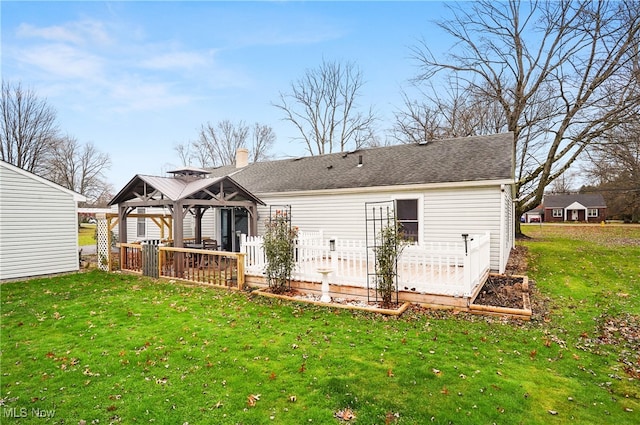 rear view of property featuring a gazebo and a yard