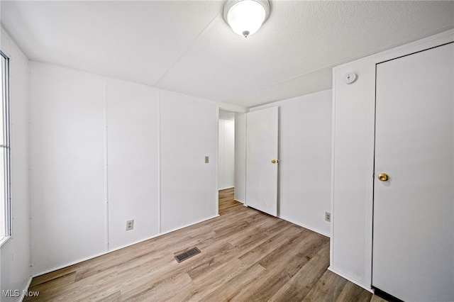 unfurnished bedroom featuring light hardwood / wood-style flooring and a textured ceiling