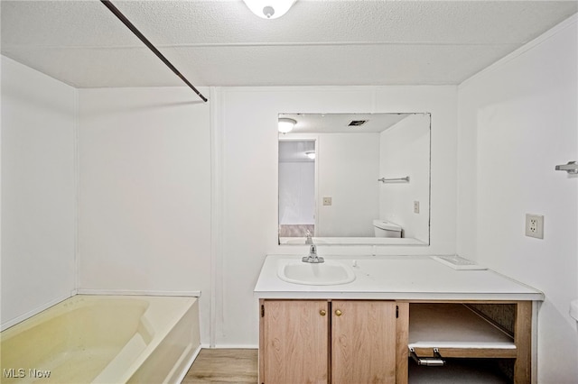 bathroom with hardwood / wood-style flooring, vanity, and toilet