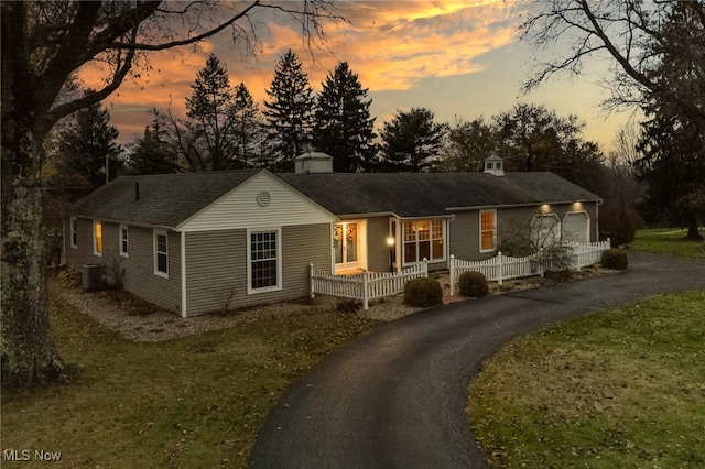 single story home with central air condition unit, a yard, and covered porch