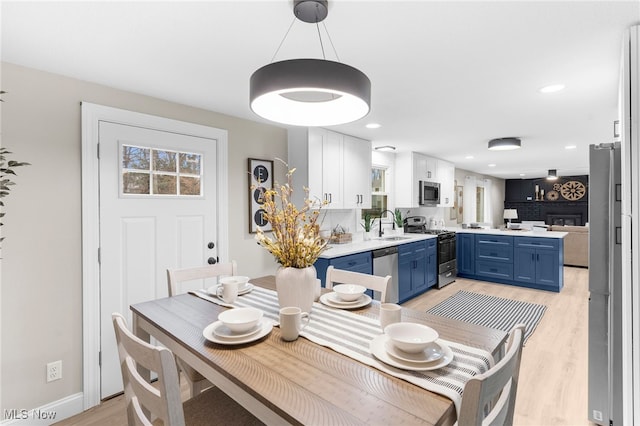 dining area featuring light wood-type flooring and sink