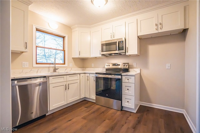 kitchen with sink, dark hardwood / wood-style flooring, a textured ceiling, white cabinets, and appliances with stainless steel finishes