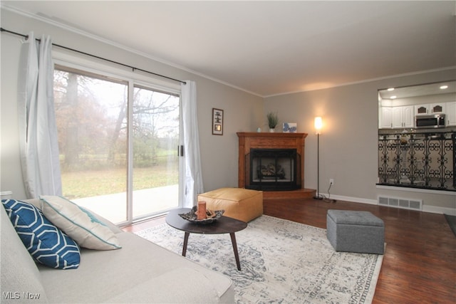 living room with dark hardwood / wood-style flooring and ornamental molding