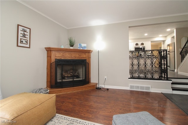 living room with hardwood / wood-style flooring and crown molding