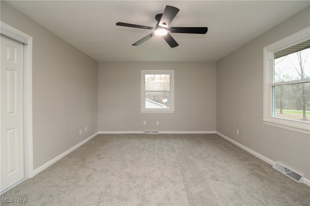 unfurnished room featuring light carpet and ceiling fan