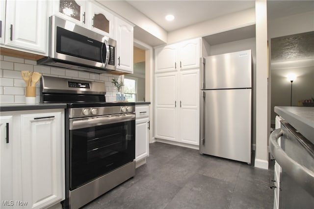 kitchen with stainless steel appliances, white cabinetry, and tasteful backsplash