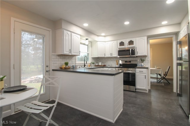 kitchen with plenty of natural light, white cabinetry, kitchen peninsula, and appliances with stainless steel finishes