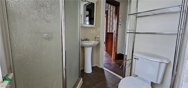 bathroom featuring sink, toilet, a shower with shower door, and hardwood / wood-style flooring