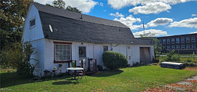 back of property featuring a garage and a lawn