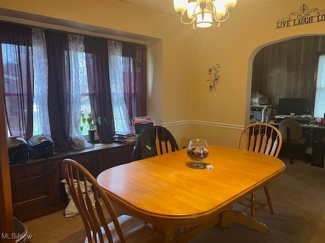 dining space with carpet floors and an inviting chandelier