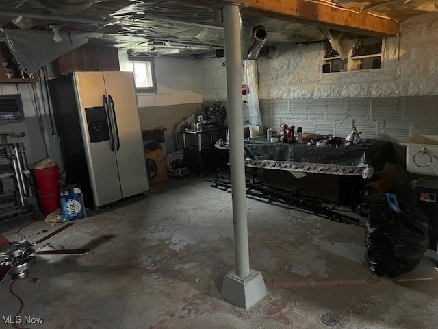 basement with stainless steel fridge with ice dispenser