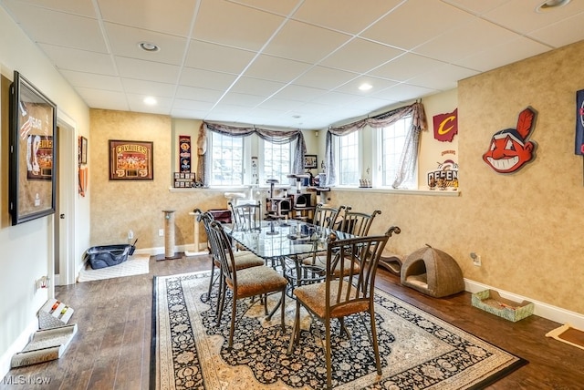 dining room with hardwood / wood-style flooring and a paneled ceiling