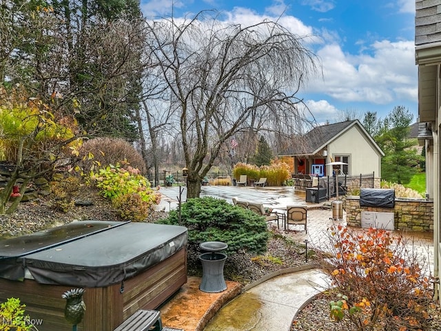 view of yard featuring exterior kitchen, a patio, and a hot tub