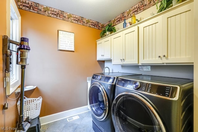 washroom featuring washer and dryer and cabinets