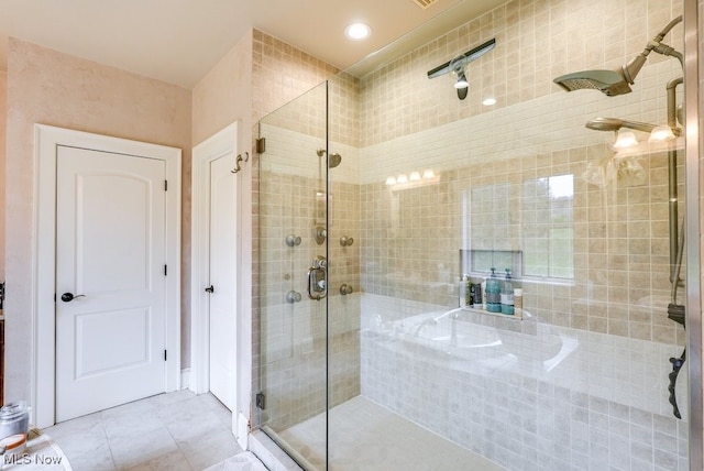 bathroom featuring tile patterned flooring and a shower with shower door