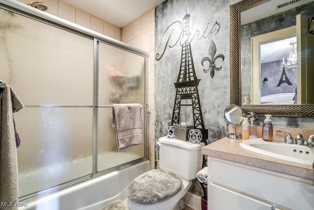 full bathroom featuring vanity, toilet, and shower / bath combination with glass door