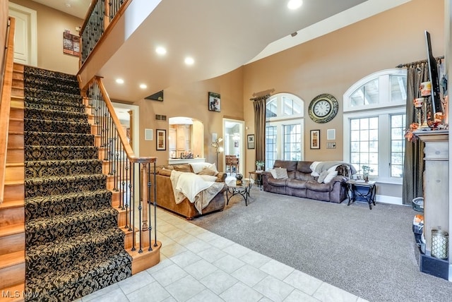 carpeted living room with a towering ceiling