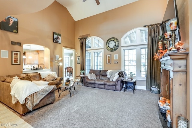 living room featuring ceiling fan, carpet floors, and high vaulted ceiling